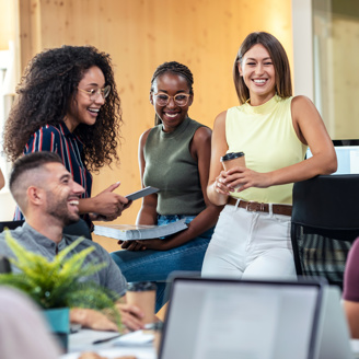 A mixed group of young people smiling and working in an office setting